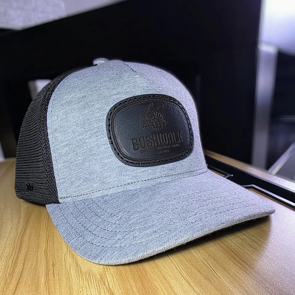Black leather patch with a tonal mark on a grey trucker cap