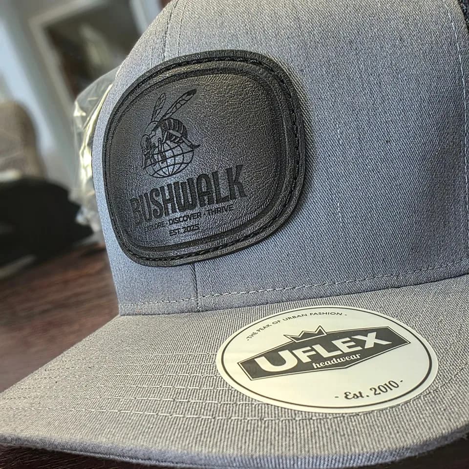 Black leather patch with a pressed tonal mark on a grey cap