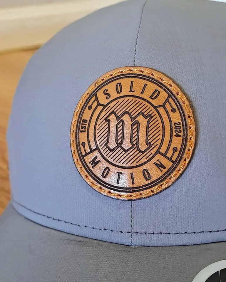 Circular engraved patch on a grey cap
